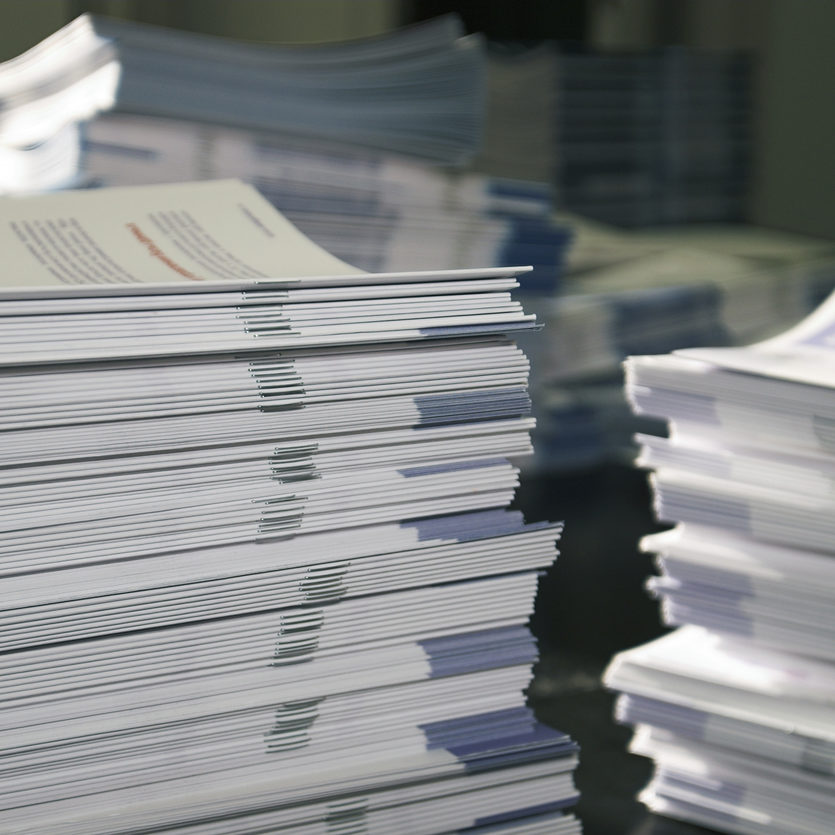 Piles of handout papers lying on a table.